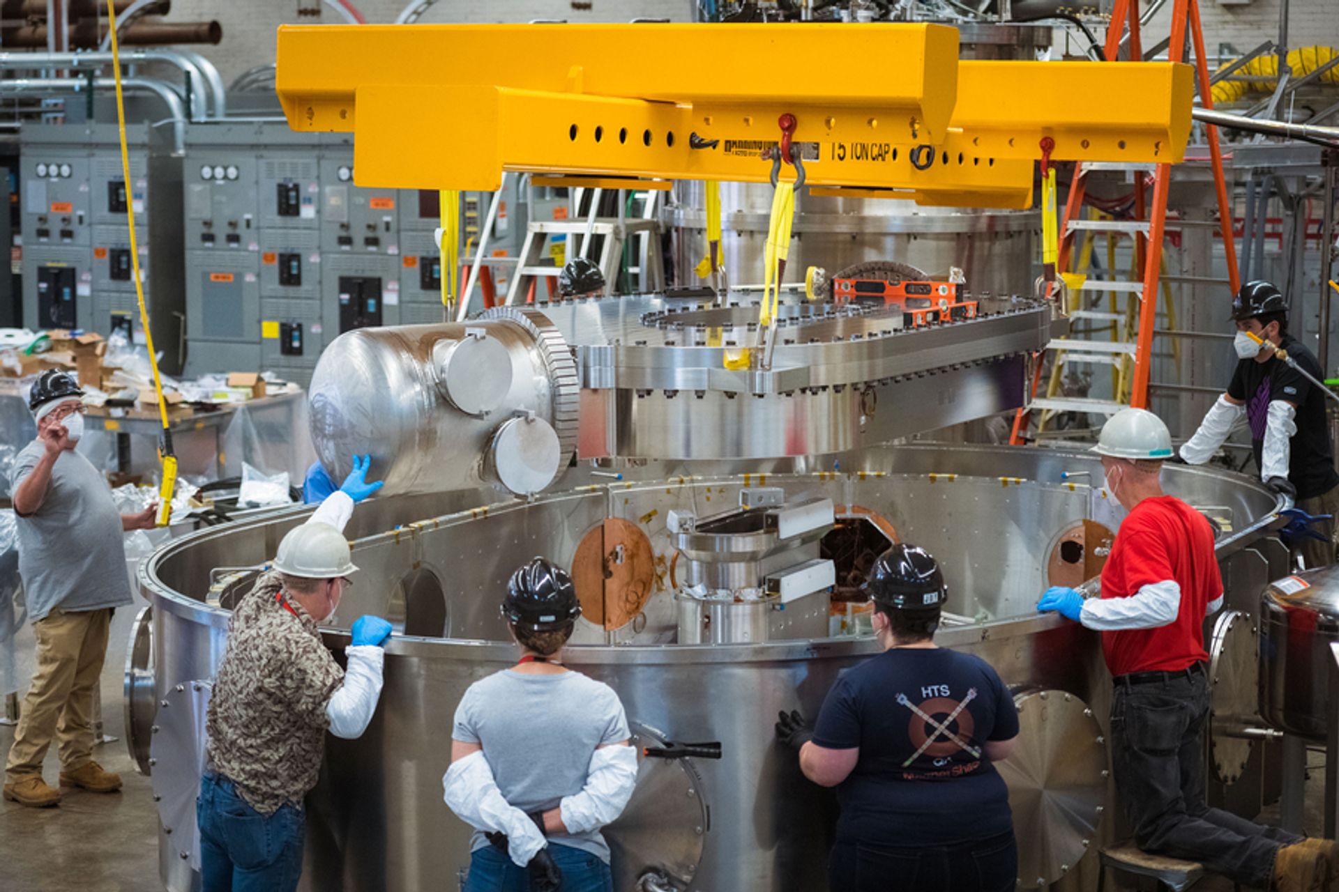 Un team di ingegneri e scienziati della CFS e del PSFC del Massachusetts Institute of Technology abbassano il magnete superconduttore nel banco di prova in cui il medesimo è stato raffreddato e alimentato per produrre un campo magnetico di 20 tesla. (Foto: Gretchen Ertl, CFS/MIT-PSFC, 2021)