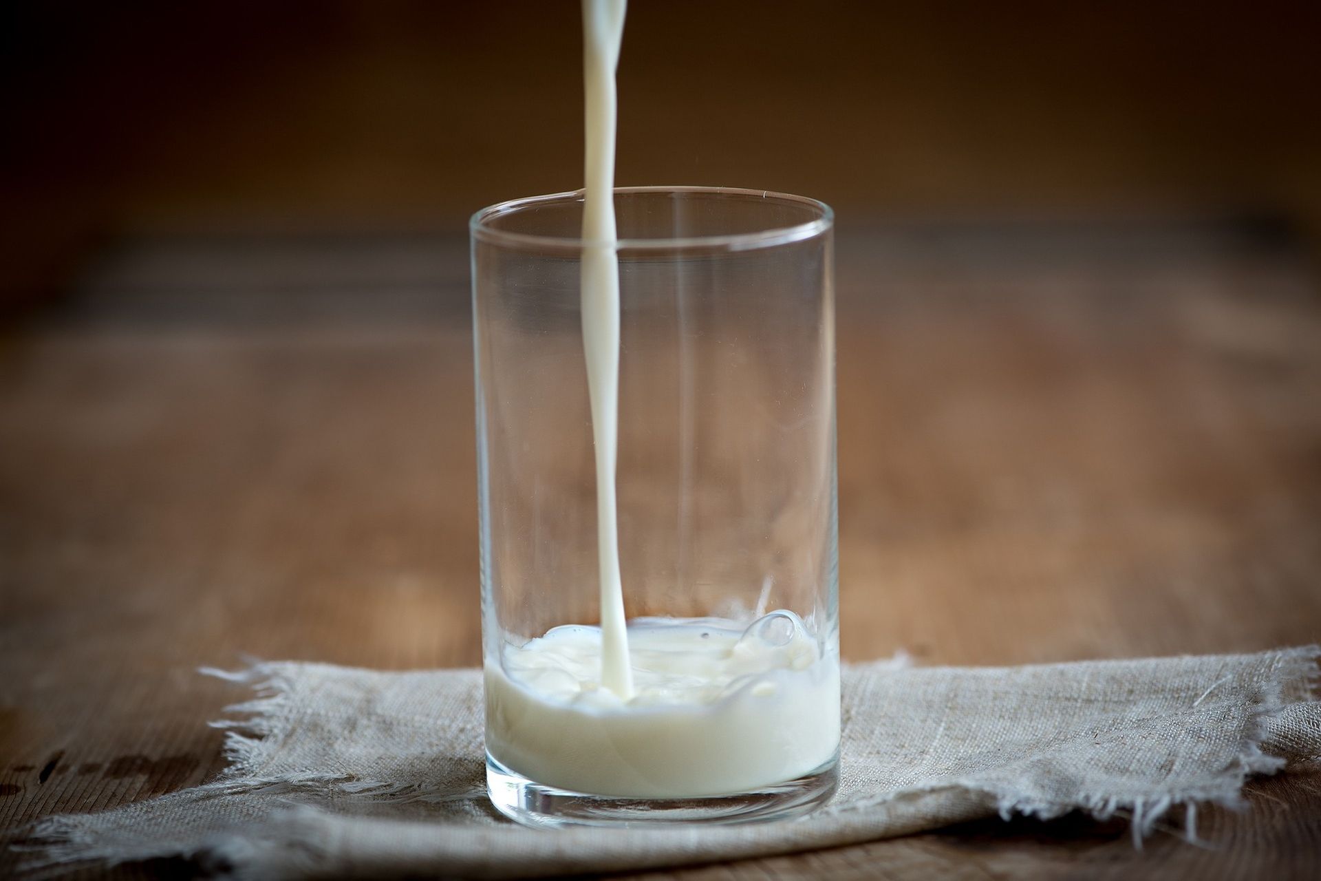 Latte versato dall'alto in un bicchiere trasparente