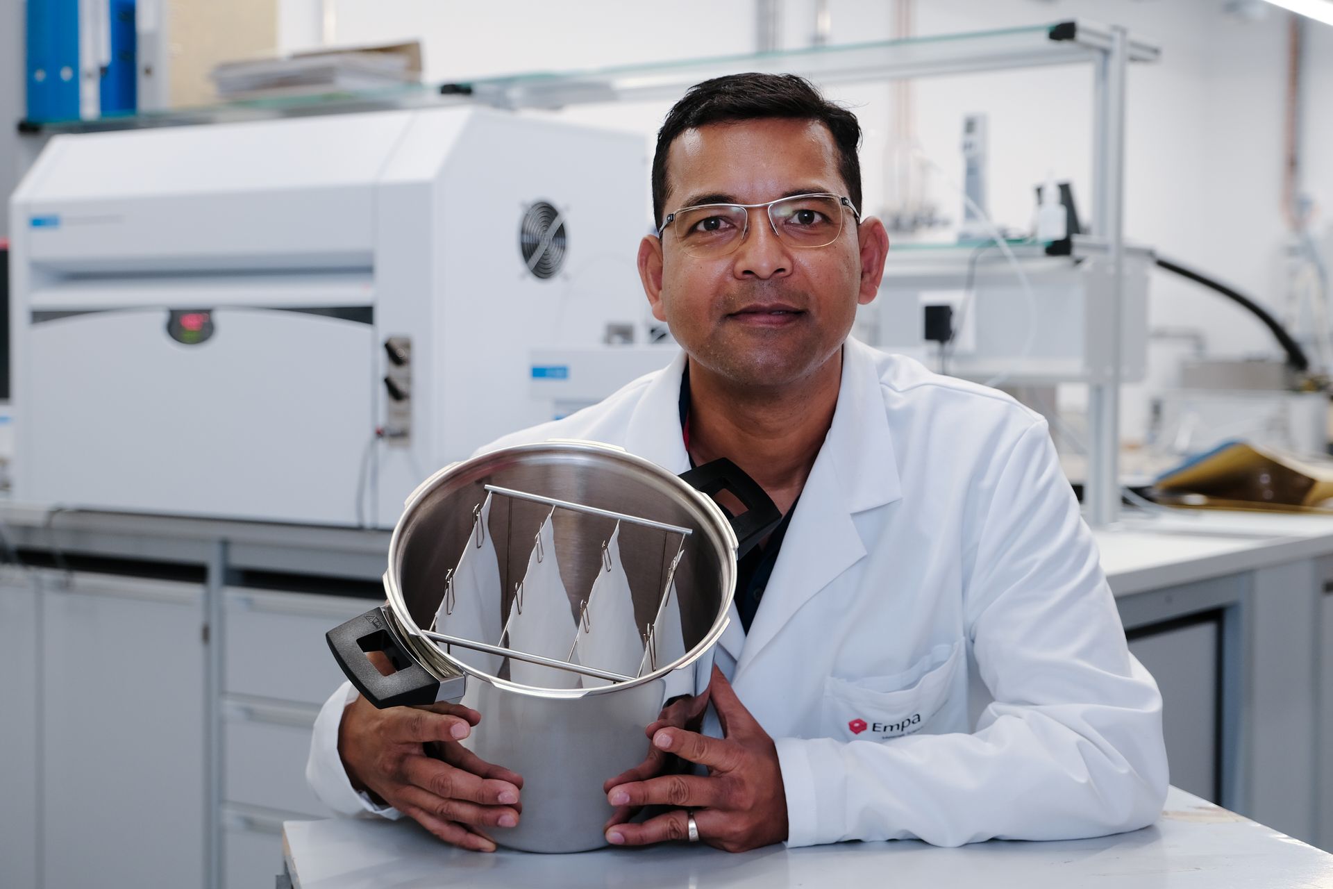 Sabyasachi Gaan, chimico ed esperto di polimeri del gabinetto Advanced Fibers dei Laboratori Federali Svizzeri per la Scienza e la Tecnologia dei Materiali, con alcune pezze di cotone reso ignifugo senza formaldeide e più confortevole