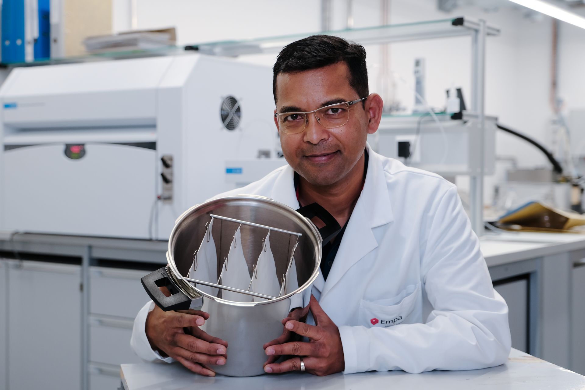 Sabyasachi Gaan, chimico ed esperto di polimeri del gabinetto Advanced Fibers dei Laboratori Federali Svizzeri per la Scienza e la Tecnologia dei Materiali, con alcune pezze di cotone reso ignifugo senza formaldeide e più confortevole
