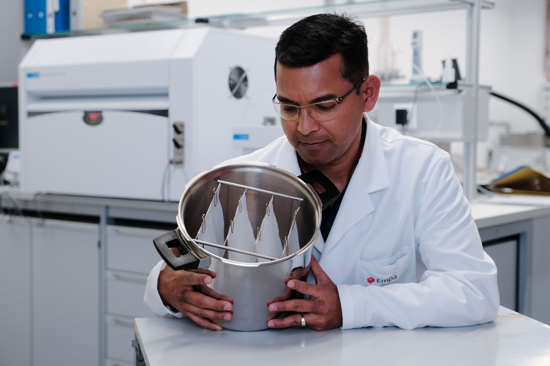 Sabyasachi Gaan, chimico ed esperto di polimeri del gabinetto Advanced Fibers dei Laboratori Federali Svizzeri per la Scienza e la Tecnologia dei Materiali, con alcune pezze di cotone reso ignifugo senza formaldeide e più confortevole