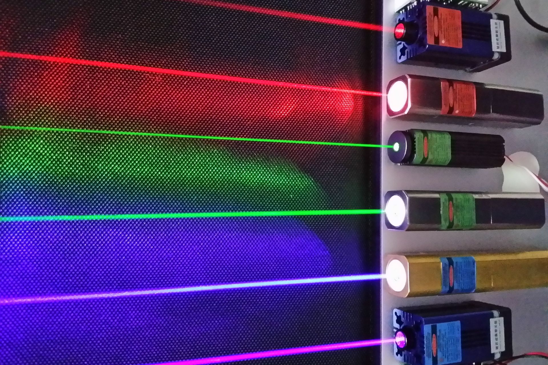 Sei LASER commerciali in funzione, che mostrano una gamma di diversi fasci di luce colorata che possono essere prodotti, dal rosso al violetto; dall'alto al basso, le lunghezze d'onda della luce sono: 660, 635, 532, 520, 445 e 405 nanometri rispettivamente (Foto: Q-line)