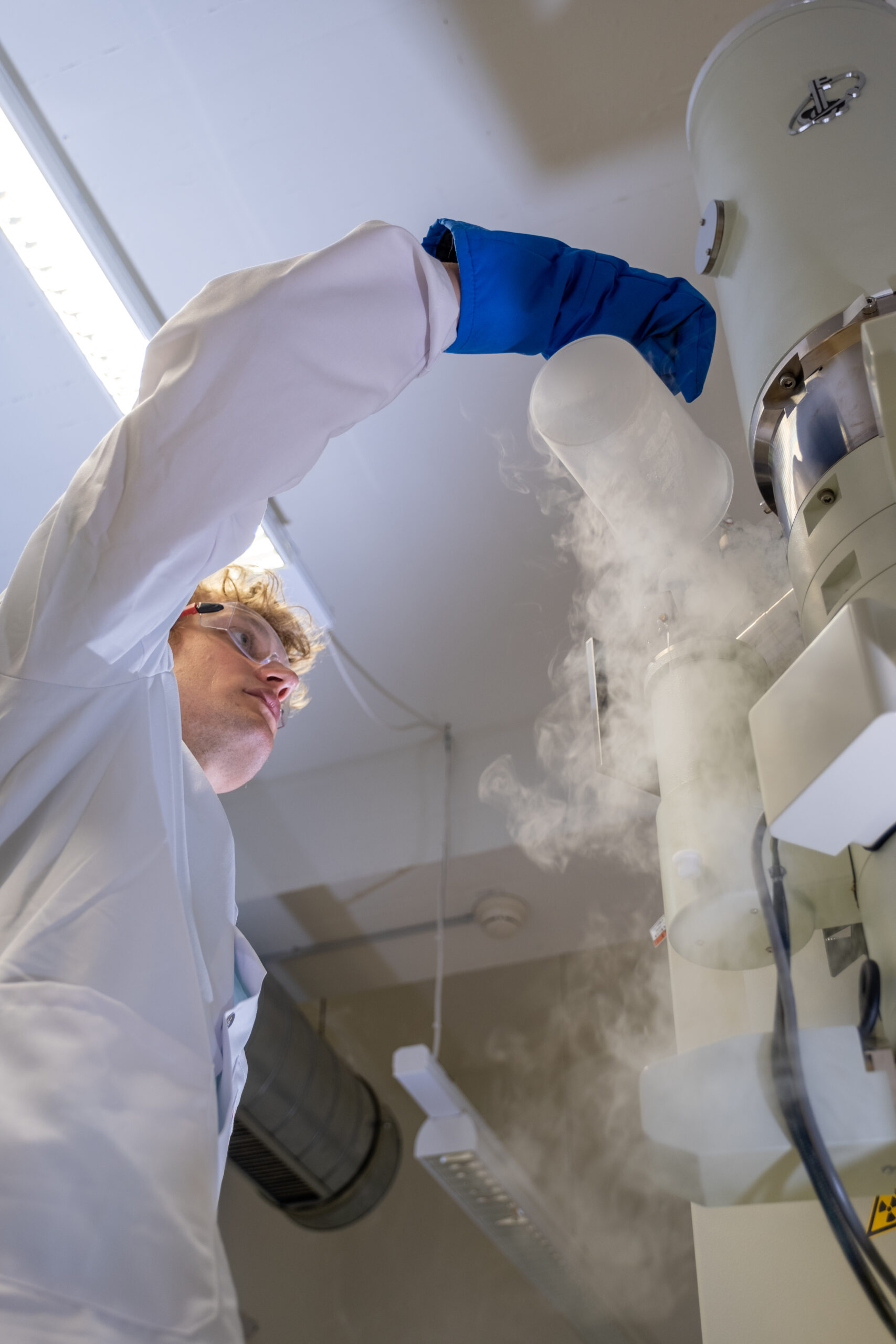 Fuoco e ghiaccio: Lukas Gerken, ricercatore dell'EMPA a San Gallo, produce nanoparticelle per la radioterapia del cancro, utilizzando la cosiddetta “sintesi alla fiamma”: onde rendere visibili le minuscole particelle di metallo, il microscopio elettronico viene raffreddato a temperature di congelamento con azoto liquido (Foto: EMPA/Politecnico Federale di Zurigo)