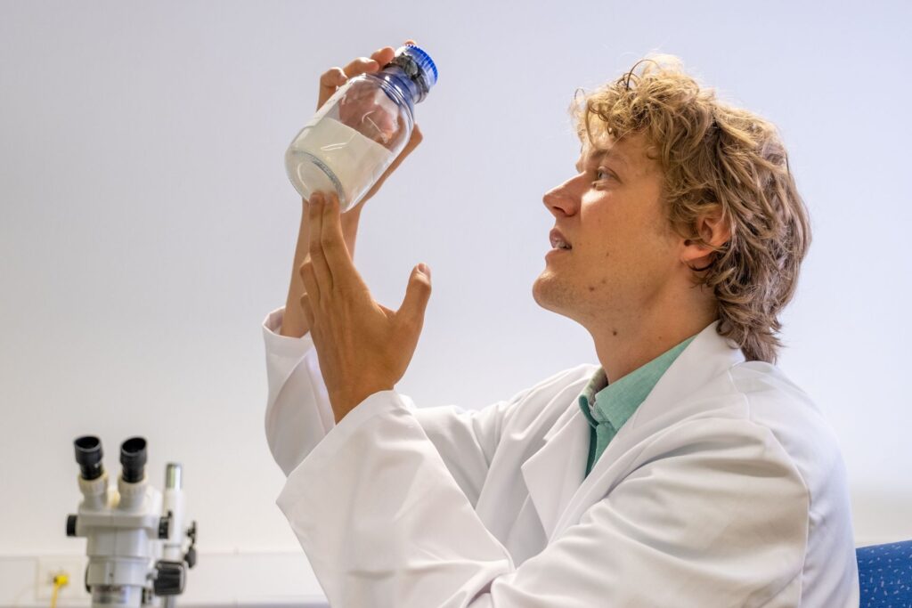 Fuoco e ghiaccio: Lukas Gerken, ricercatore dell'EMPA a San Gallo, produce nanoparticelle per la radioterapia del cancro, utilizzando la cosiddetta “sintesi alla fiamma”: onde rendere visibili le minuscole particelle di metallo, il microscopio elettronico viene raffreddato a temperature di congelamento con azoto liquido (Foto: EMPA/Politecnico Federale di Zurigo)