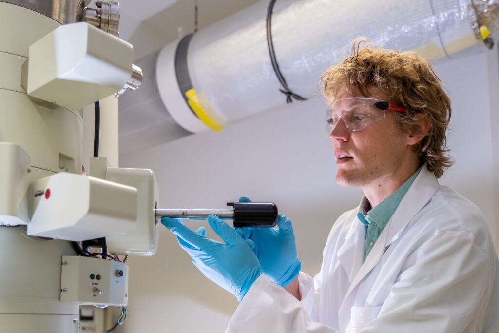 Fuoco e ghiaccio: Lukas Gerken, ricercatore dell'EMPA a San Gallo, produce nanoparticelle per la radioterapia del cancro, utilizzando la cosiddetta “sintesi alla fiamma”: onde rendere visibili le minuscole particelle di metallo, il microscopio elettronico viene raffreddato a temperature di congelamento con azoto liquido (Foto: EMPA/Politecnico Federale di Zurigo)