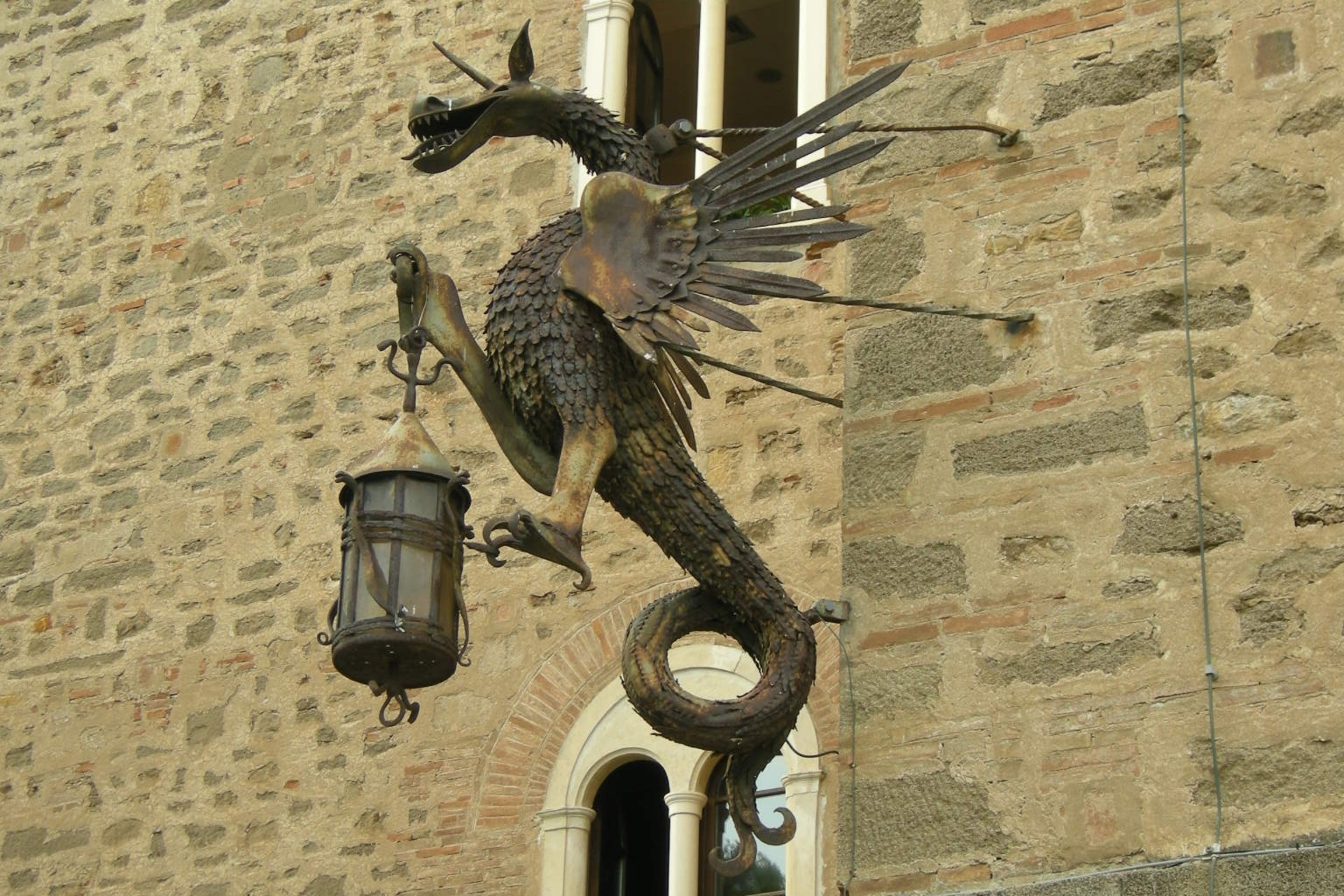 Il dragone portafiaccola sulle mura di Castello Pasquini a Castiglioncello di Rosignano Marittimo