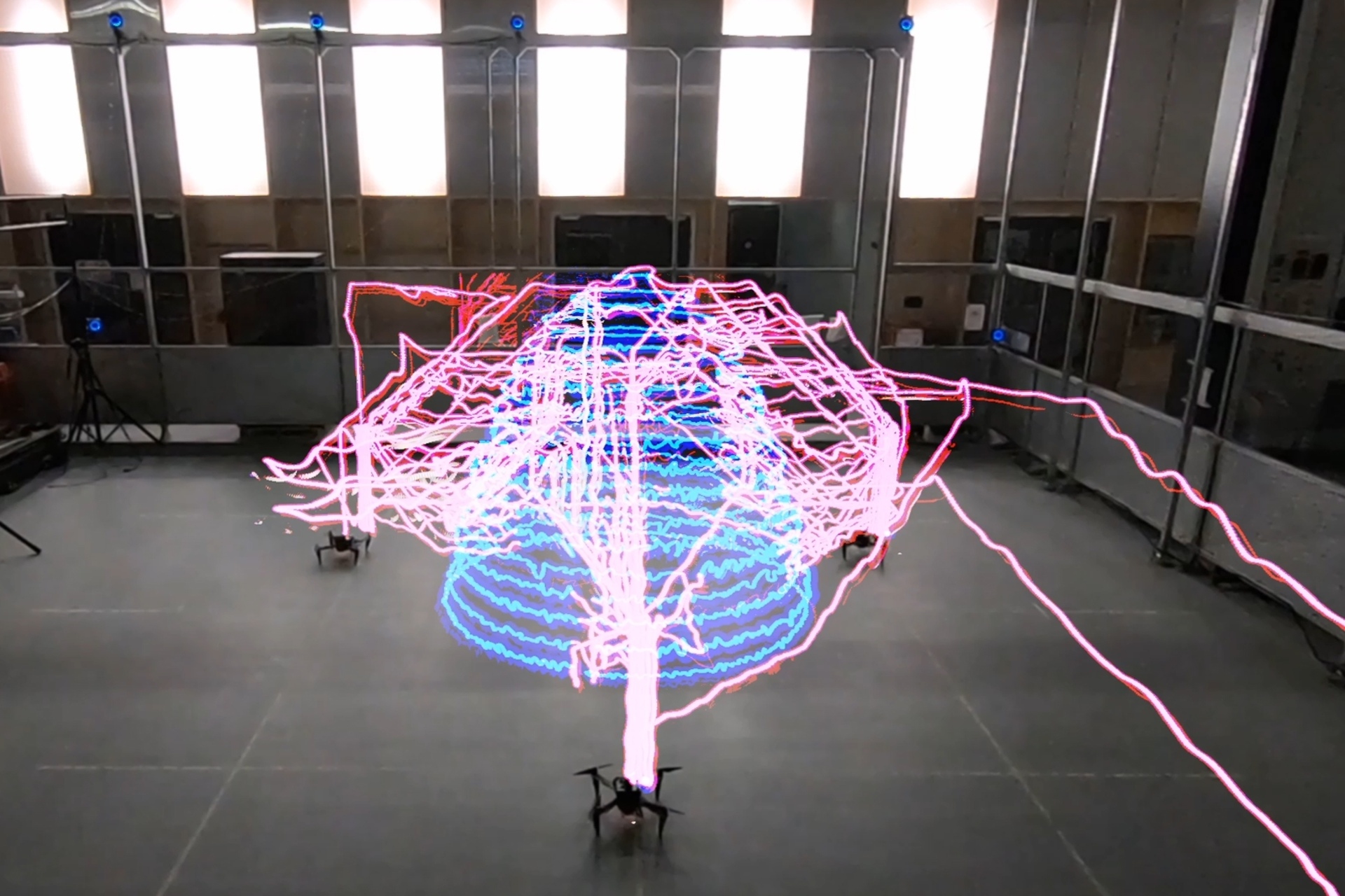 Droni collaborativi: una traccia luminosa in timelapse che dimostra la coordinazione multi-agente del team di robot Aerial AM