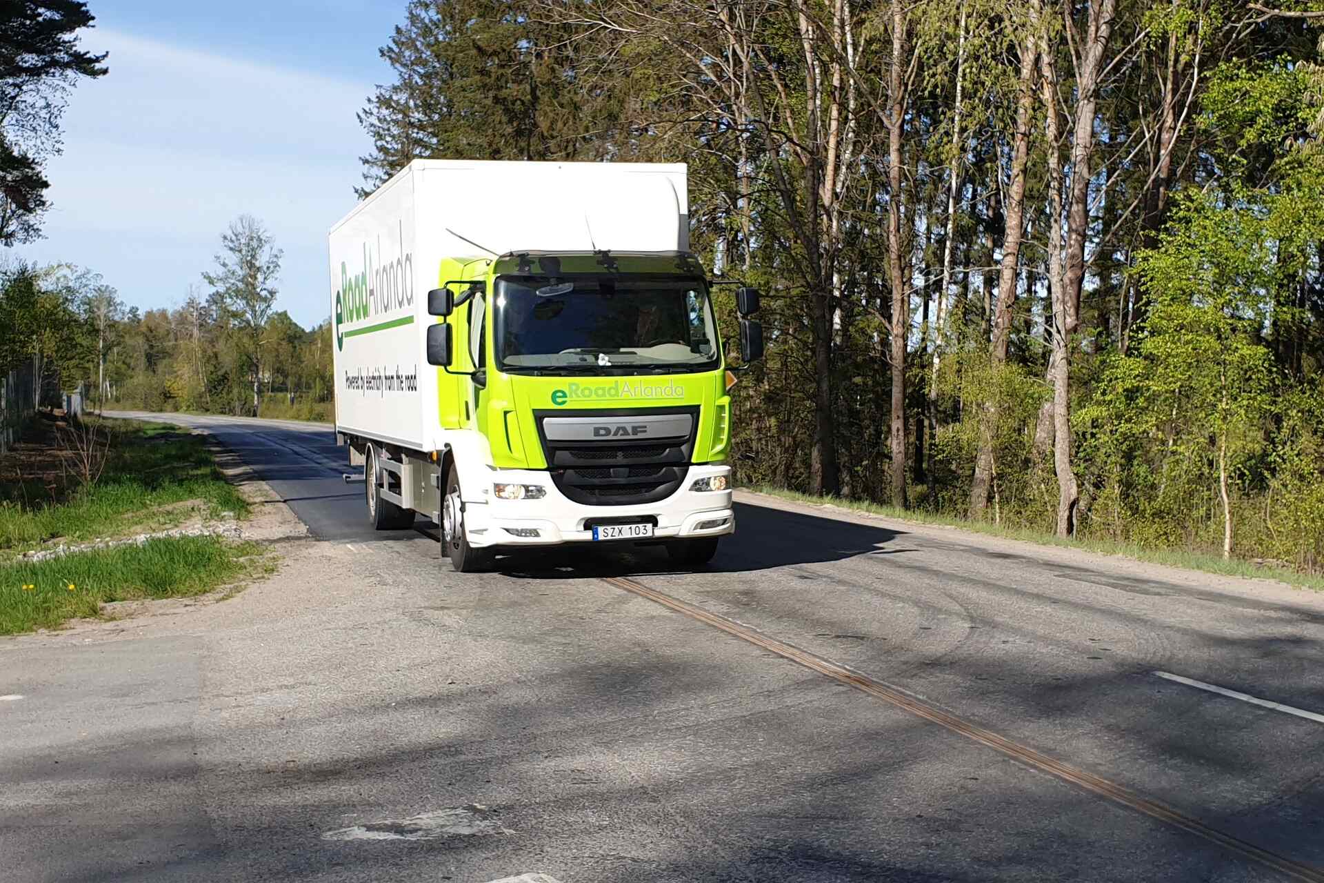 Strade elettrificate: un camion nella livrea di eRoadArlanda vicino Stoccolma sulla carreggiata dotata di binario