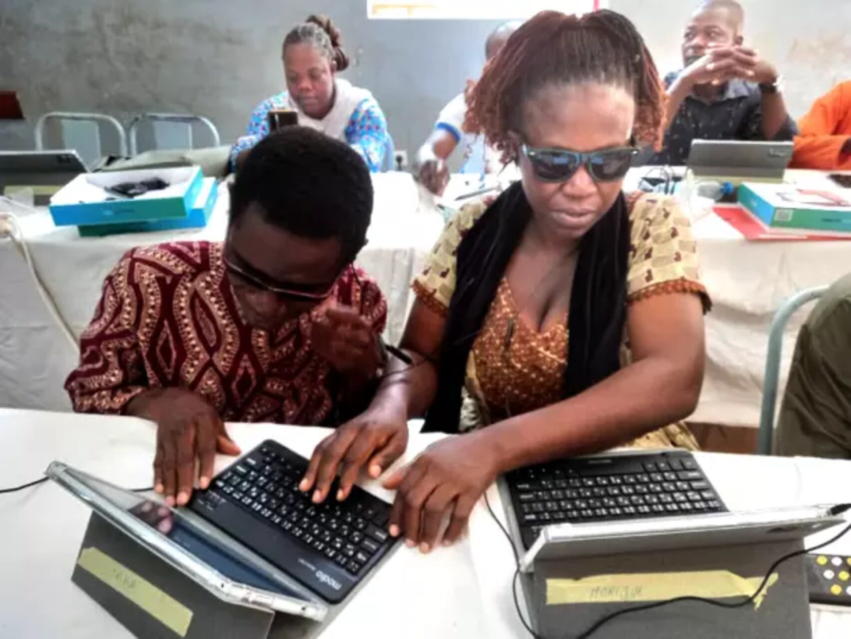 Burkina Faso: due docenti ciechi con tablet e tastiera Braille durante una sessione formativa, simboli di inclusione e accessibilità nell’educazione e nello sviluppo digitale nel cuore dell’Africa