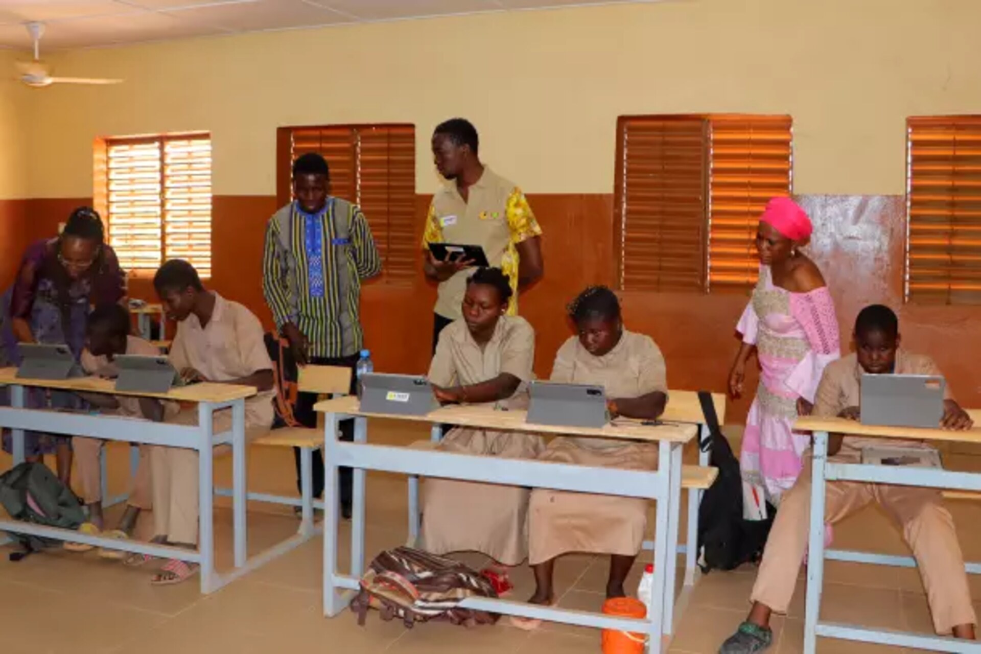 Burkina Faso: gruppo di insegnanti in aula con tablet e strumenti digitali, impegnati in una formazione innovativa per garantire pari opportunità e accessibilità nello studio a studenti disabili