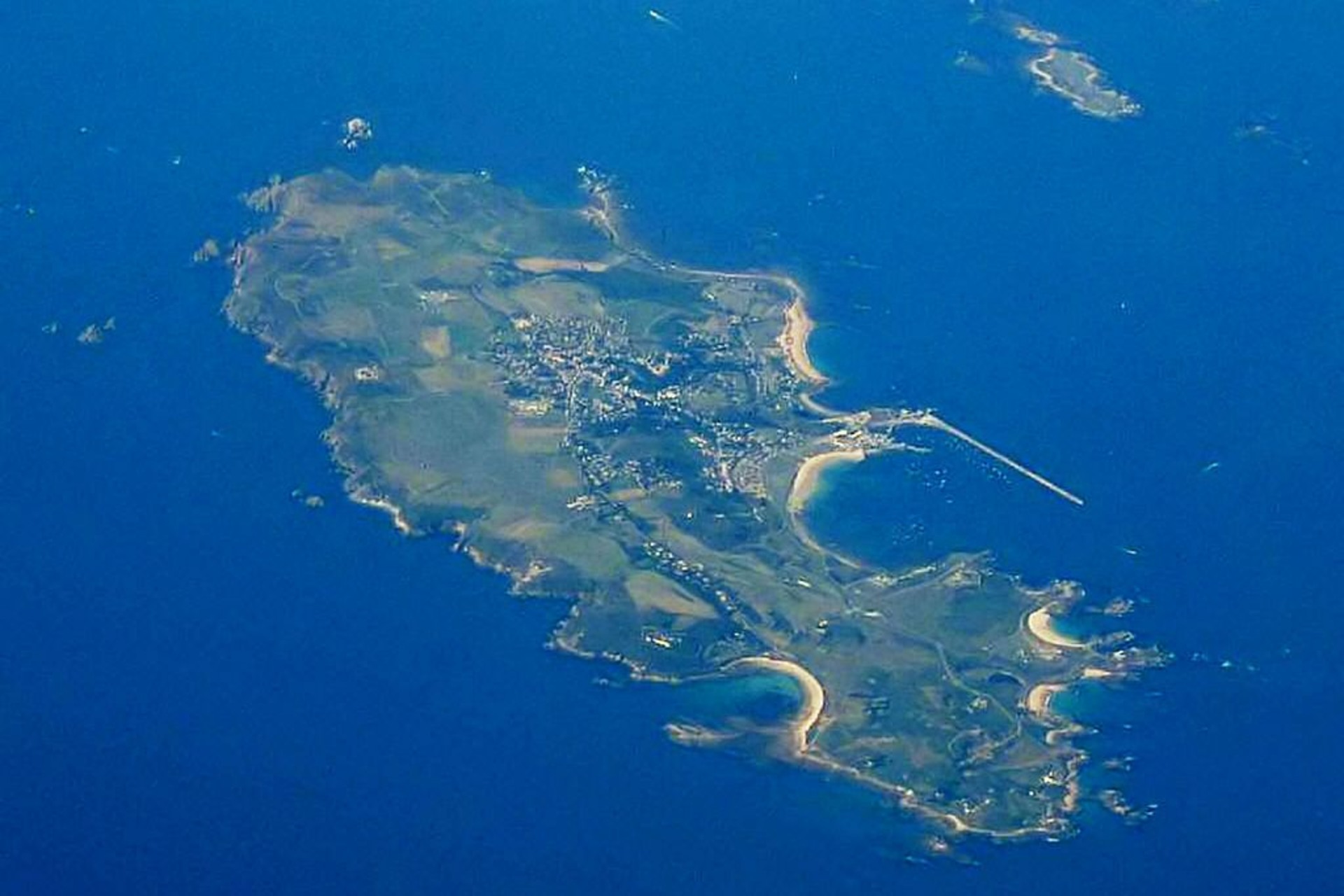 Alderney: vista dall’alto l’isola mostra una costa frastagliata e fondali profondi che alimentano correnti marine fortissime, ideali per l’installazione di turbine mareomotrici e per progetti pilota basati su dati reali, sostenibilità e innovazione