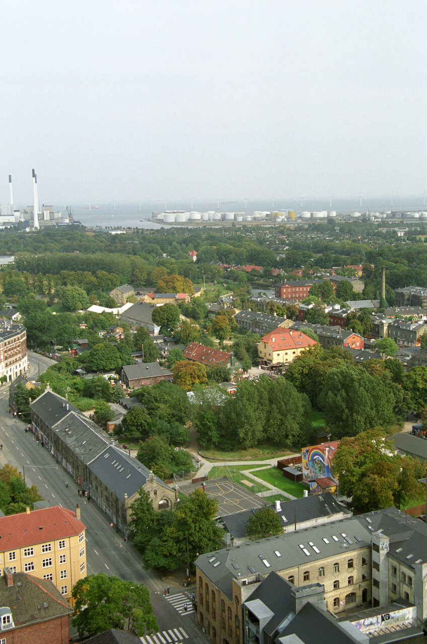 Christiania è un quartiere alternativo fondato negli anni Settanta, oggi laboratorio urbano che unisce autonomia comunitaria, riqualificazione abitativa ed energie rinnovabili diffuse