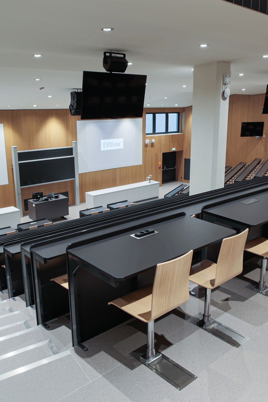 Classe ibrida del futuro: aula universitaria evoluta che combina architettura flessibile, display interattivi, piattaforme digitali e collaborazione internazionale tra docenti e studenti