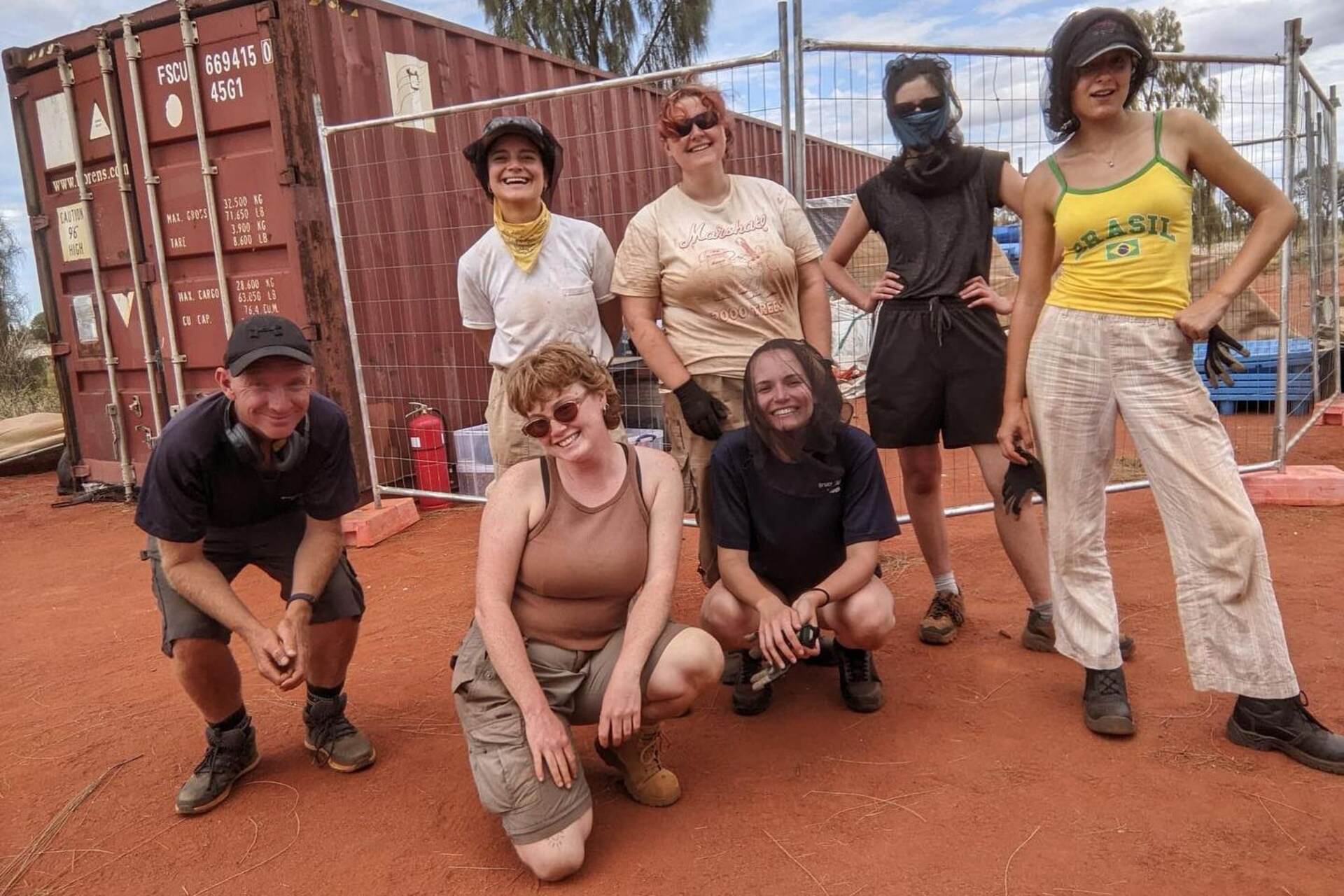 Persone ritratte insieme davanti a Uluṟu, tra membri della comunità locale e collaboratori di Bruce Munro: l’immagine riflette dialogo culturale, cooperazione e partecipazione alla realizzazione di Field of Light