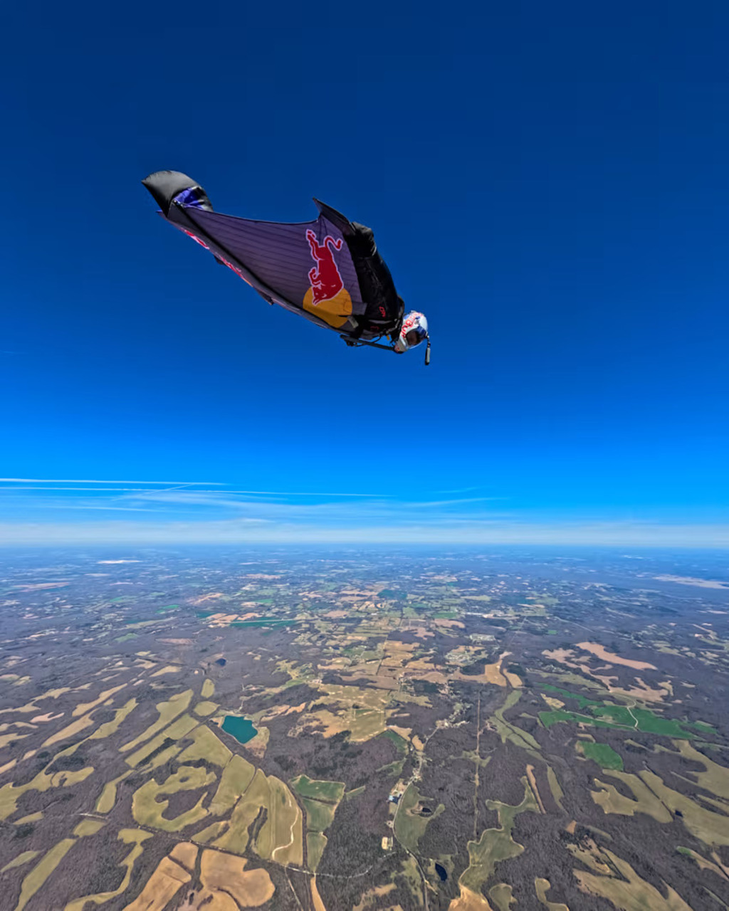 Wingsuit flying: immagine di volo umano ad alta quota con tuta alare, tecnologie indossabili e sistemi di supporto che rappresentano l’evoluzione dell’aerodinamica personale e delle pratiche sperimentali negli sport estremi contemporanei
