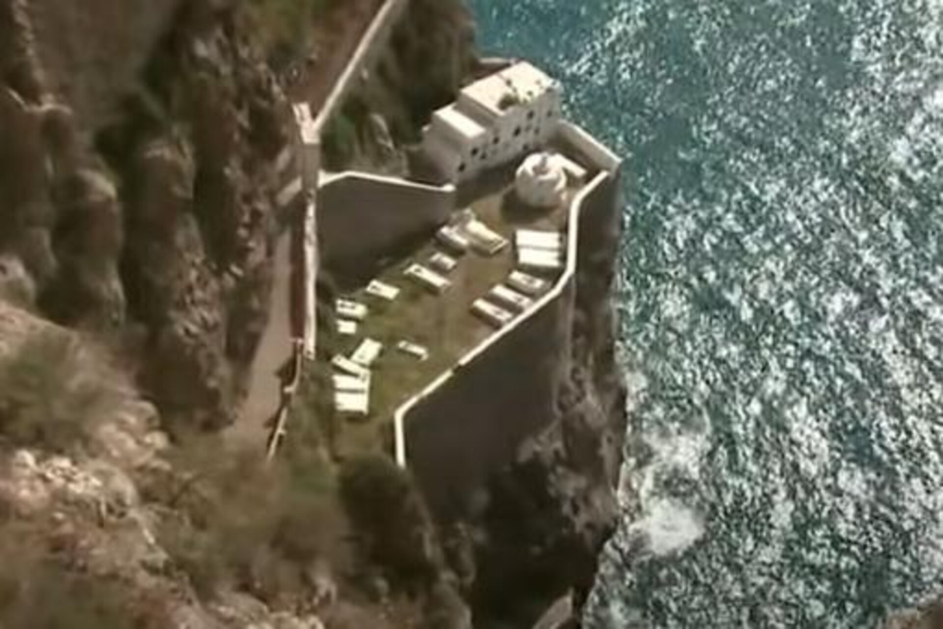 Peñón de Vélez: vista dalla costa marocchina della roccia fortificata collegata alla terraferma, esempio di enclave strategica tra Europa e Africa con presidio permanente e alta rilevanza geopolitica.