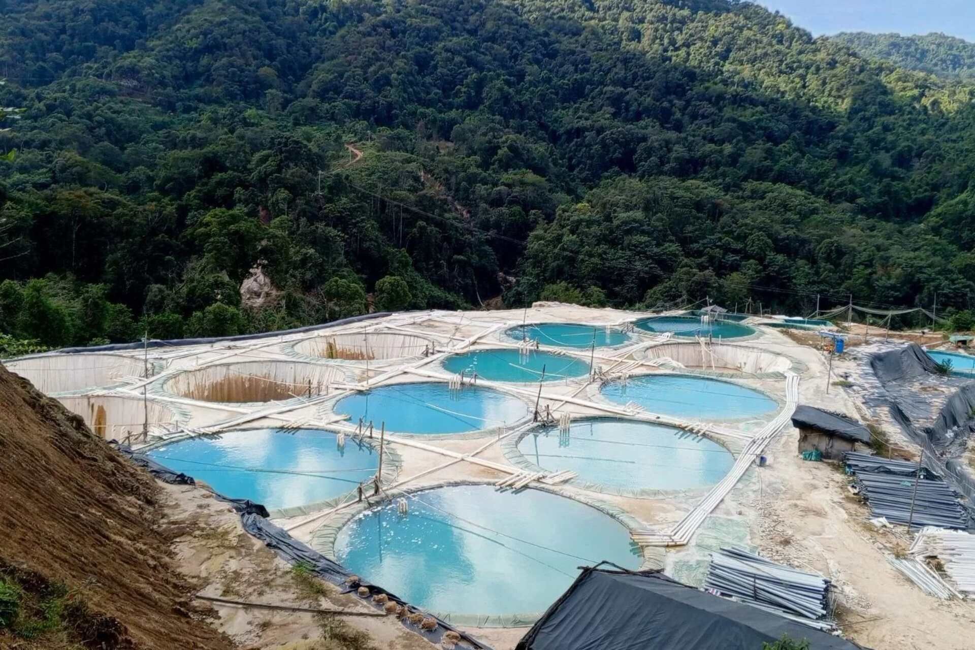 Stato Kachin: area di estrazione di terre rare nel nord del Myanmar con perforazioni per l’in situ leaching, vasche di raccolta e paesaggi montani interessati da attività minerarie legate ai minerali critici per la transizione energetica globale