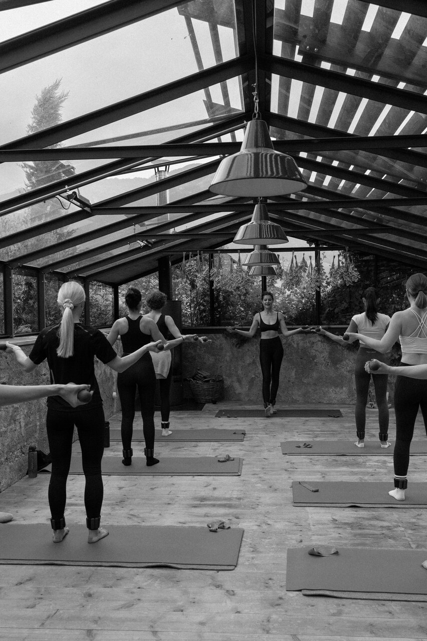 Pilates: sessione di allenamento in studio attrezzato con reformer e macchine professionali, pratica focalizzata su postura, controllo, respirazione e benessere integrato in ambiente luminoso e curato