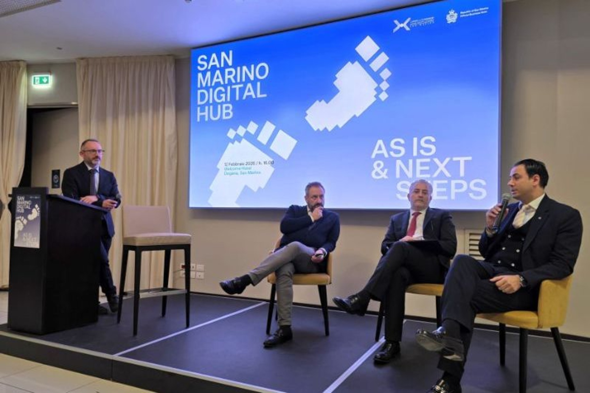 San Marino: conferenza con panel, schermi e materiali informativi dedicati all’ecosistema digitale sammarinese, tra strategie industriali, attrazione di capitali, formazione e innovazione per il futuro
