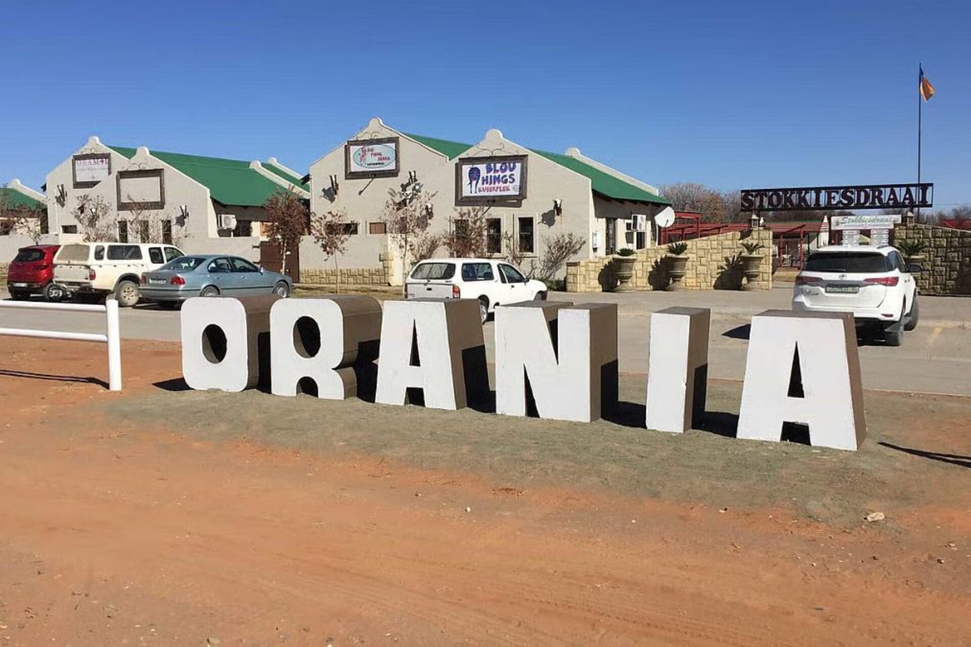 Orania: immagini della cittadina sudafricana fra abitazioni, campi, monumenti, scuole e strutture locali che mostrano il rapporto tra territorio, identità e organizzazione comunitaria