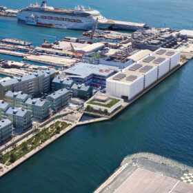 Gibilterra: paesaggio costiero vicino al porto, con edifici, passeggiate e aree verdi che raccontano il rapporto tra sviluppo urbano, infrastrutture digitali e posizione geografica strategica all’ingresso del Mediterraneo