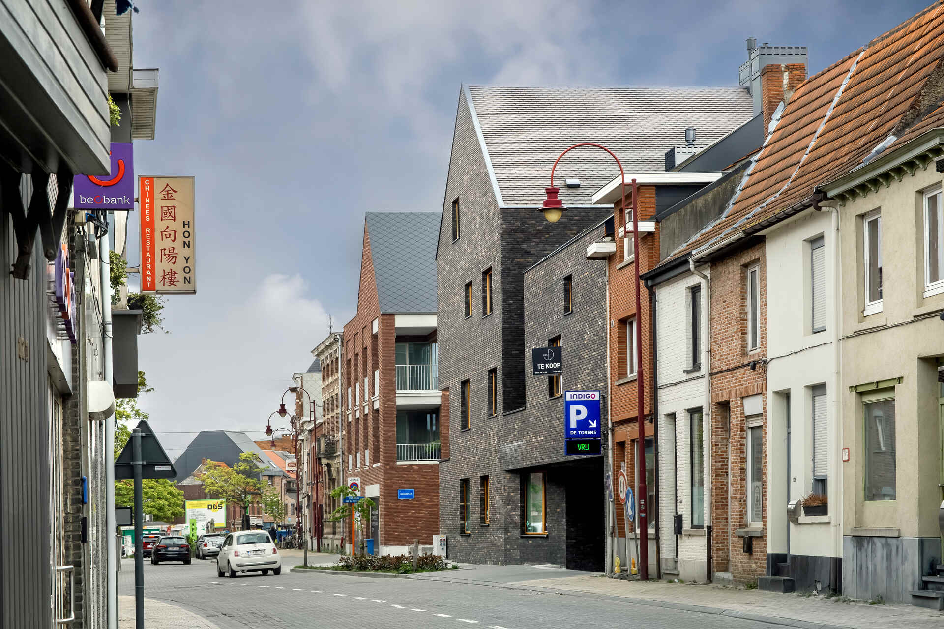 Snake Building: intervento di rigenerazione urbana ad Aarschot, in Belgio, dove residenze, commercio e spazio pubblico si integrano attraverso facciate continue, aperture e volumi irregolari
