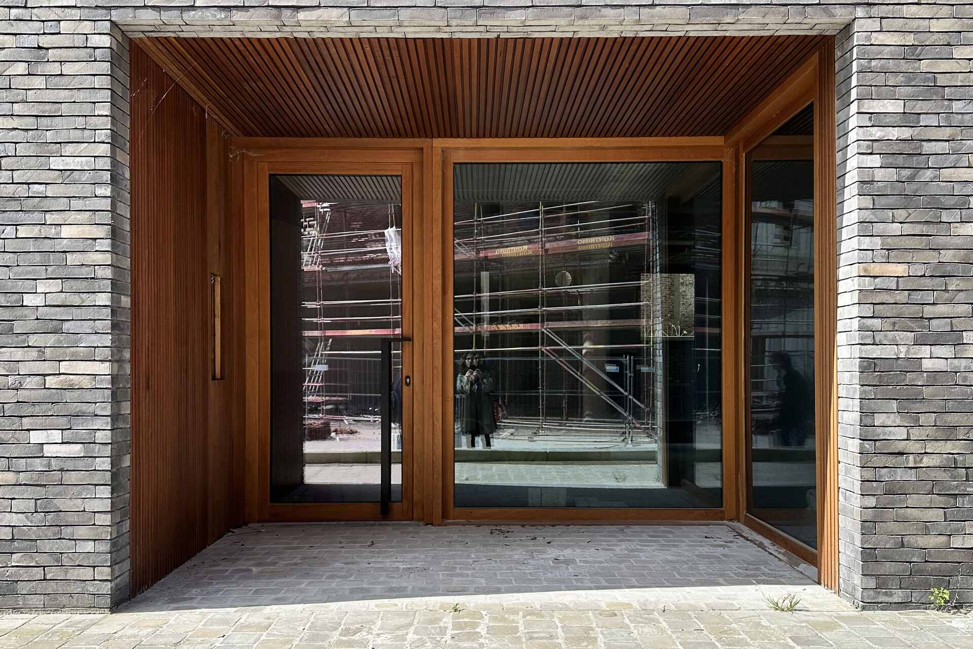 Snake Building: progetto architettonico in Belgio che rielabora i tetti e le facciate tradizionali di Aarschot attraverso una composizione contemporanea di mattoni, legno, logge e terrazze