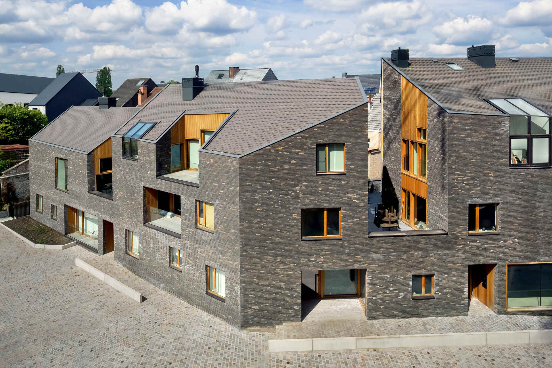 Snake Building: complesso urbano ad Aarschot, in Belgio, inserito in un’ex area industriale riconvertita con residenze, attività commerciali, percorsi pedonali, alberi e spazi pubblici integrati